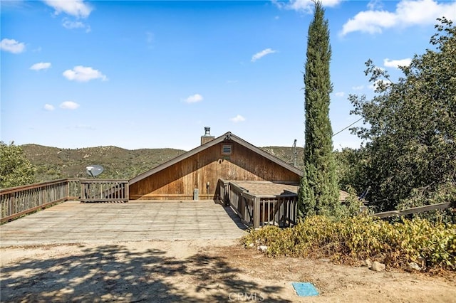 view of property exterior featuring a deck with mountain view