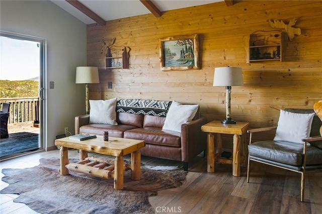 living room featuring beamed ceiling, hardwood / wood-style floors, and wooden walls