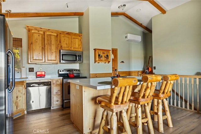 kitchen featuring a center island, a breakfast bar area, dark hardwood / wood-style flooring, stainless steel appliances, and a wall unit AC