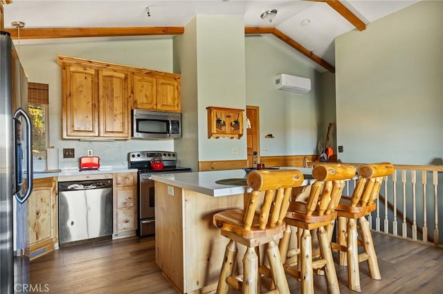 30008 Hickory Dr, Lake Arrowhead, CA 92321 - kitchen with stainless steel appliances, a wall unit AC, dark wood-style flooring, a breakfast bar, and beam ceiling