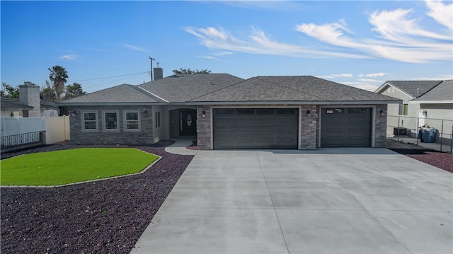 view of front facade featuring a garage, central AC unit, and a front lawn