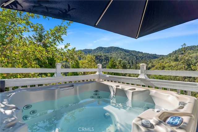 view of pool with a hot tub and a mountain view