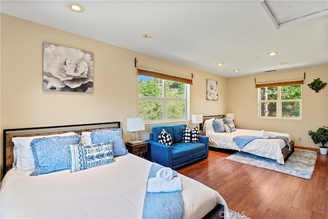 bedroom with multiple windows and hardwood / wood-style flooring