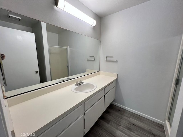 bathroom with hardwood / wood-style floors, an enclosed shower, and vanity