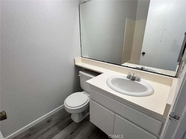 bathroom with toilet, hardwood / wood-style flooring, and vanity