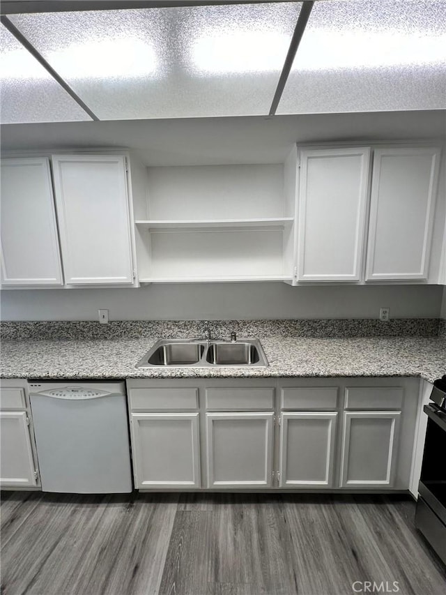 kitchen with dark hardwood / wood-style flooring, white dishwasher, white cabinets, light stone counters, and sink