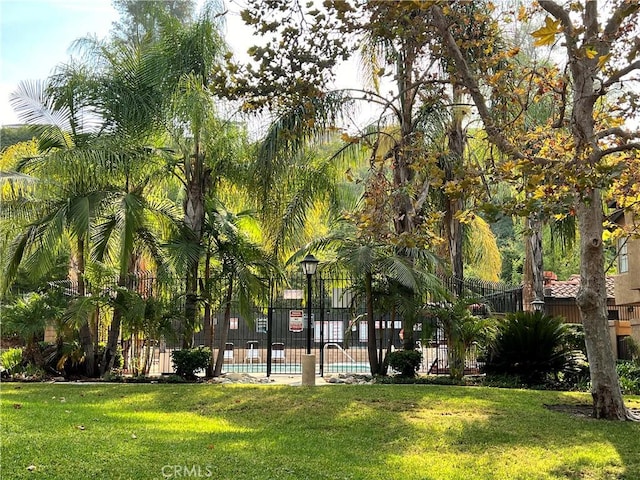 surrounding community featuring a pool and a yard