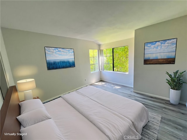 bedroom featuring hardwood / wood-style floors and vaulted ceiling