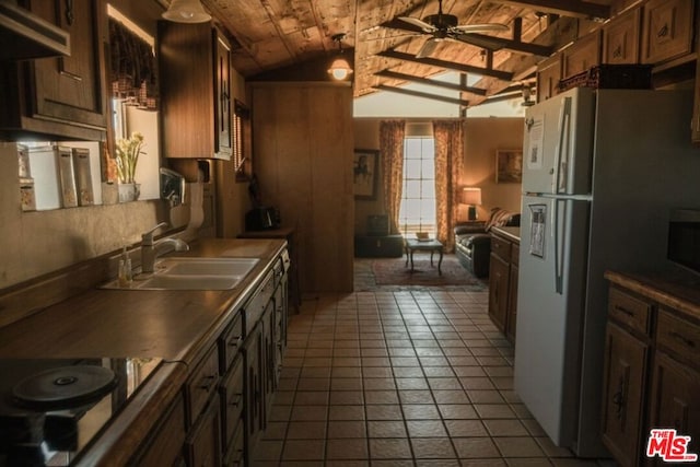 kitchen with lofted ceiling with beams, ceiling fan, wood ceiling, sink, and stovetop