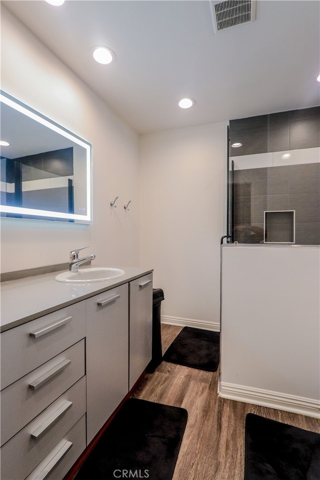 bathroom with vanity, a shower, and hardwood / wood-style floors