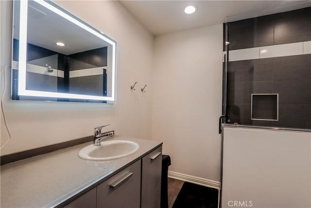 bathroom featuring a shower and vanity