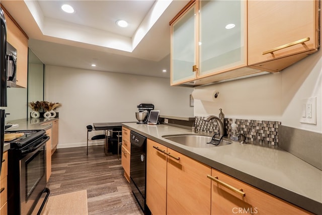 kitchen featuring a raised ceiling, light brown cabinets, black appliances, dark hardwood / wood-style floors, and sink