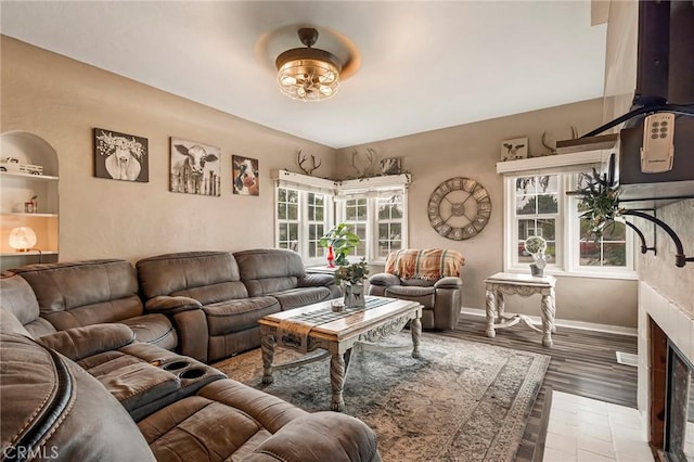 living room with ceiling fan, a fireplace, and light hardwood / wood-style floors