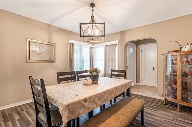 dining room with wood-type flooring and an inviting chandelier