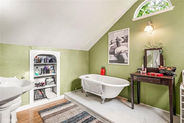 bathroom with a tub, wood-type flooring, and vaulted ceiling