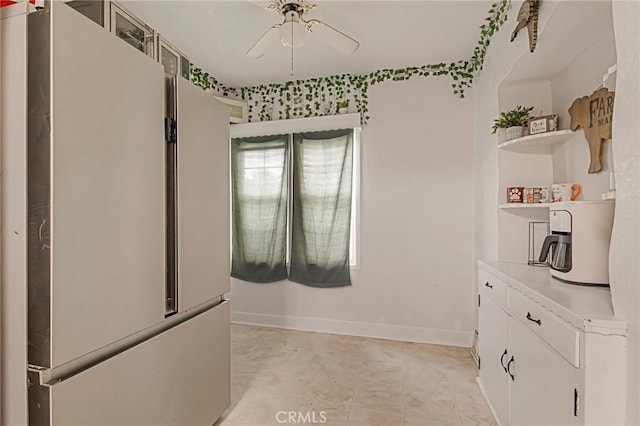 kitchen featuring white cabinets, stainless steel fridge, and ceiling fan