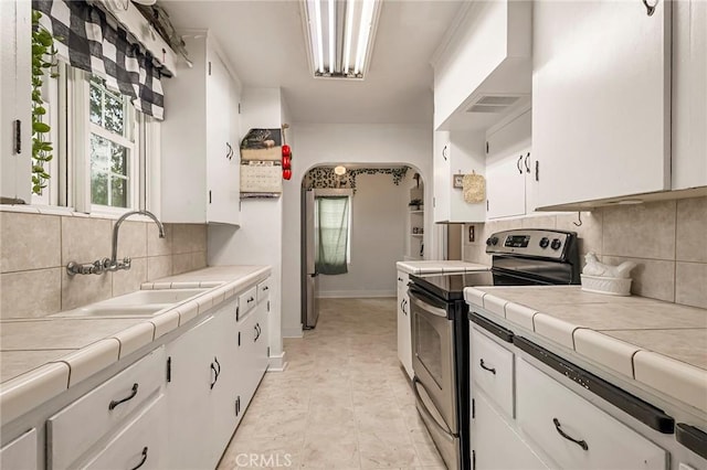 kitchen featuring tile counters and white cabinets