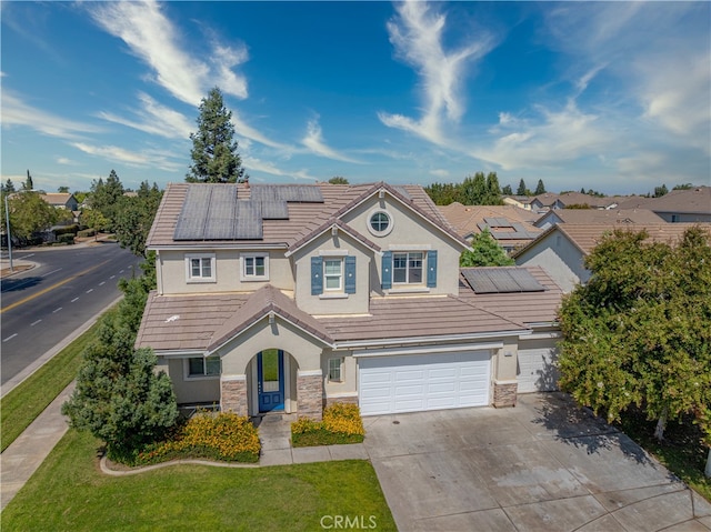 view of front of property featuring a garage, solar panels, and a front lawn