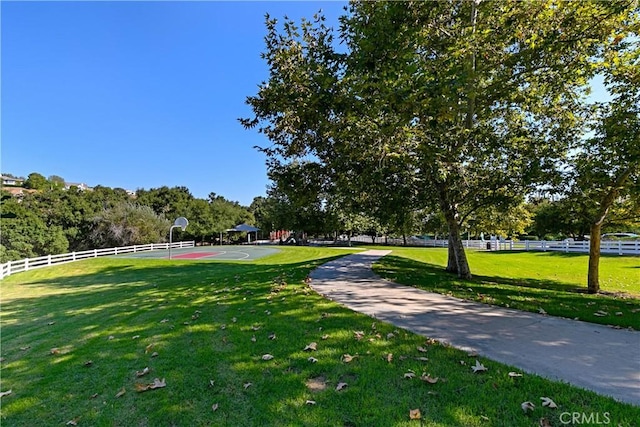 surrounding community with basketball hoop and a yard