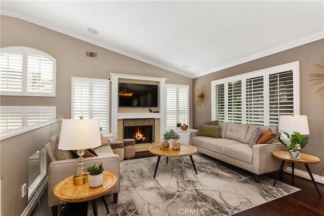 living room featuring a wealth of natural light, wood-type flooring, vaulted ceiling, and ornamental molding