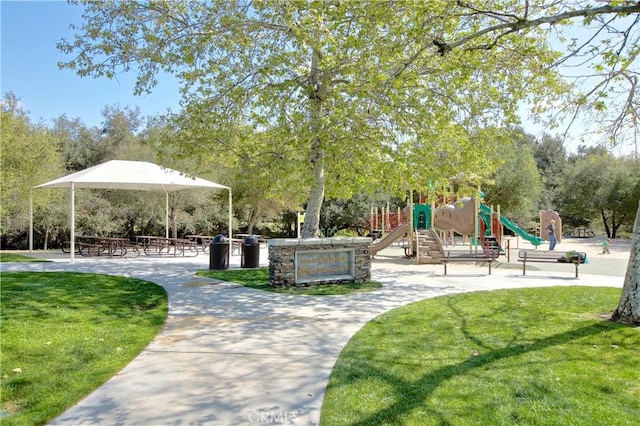 view of home's community featuring a playground and a yard