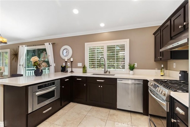 kitchen featuring sink, kitchen peninsula, stainless steel appliances, and a wealth of natural light