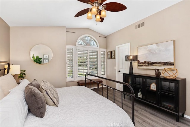 bedroom with multiple windows, ceiling fan, hardwood / wood-style floors, and vaulted ceiling