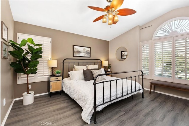 bedroom featuring multiple windows, ceiling fan, dark hardwood / wood-style floors, and vaulted ceiling