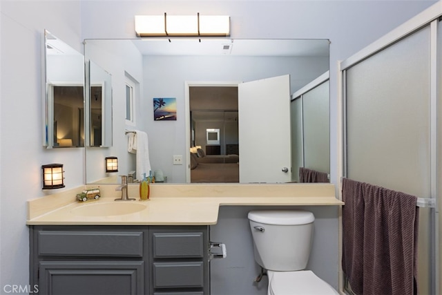 bathroom with walk in shower, vanity, and toilet