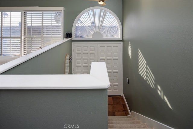 staircase featuring a wealth of natural light and tile patterned flooring