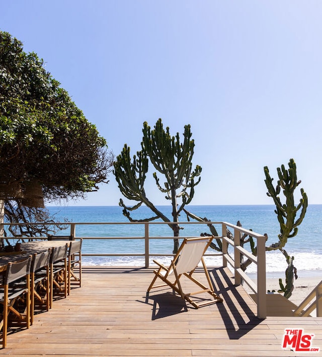 wooden deck with a water view and a view of the beach