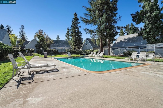 view of swimming pool featuring a yard and a patio