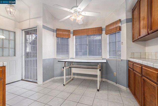 kitchen featuring tile counters, ceiling fan, and light tile patterned floors