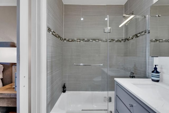 bathroom featuring shower / bath combination with glass door and vanity