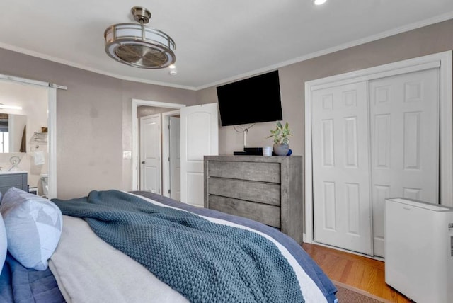 bedroom with crown molding, a closet, and light wood-type flooring