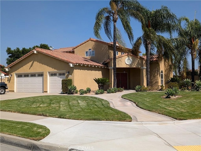 mediterranean / spanish-style home featuring a front lawn and a garage