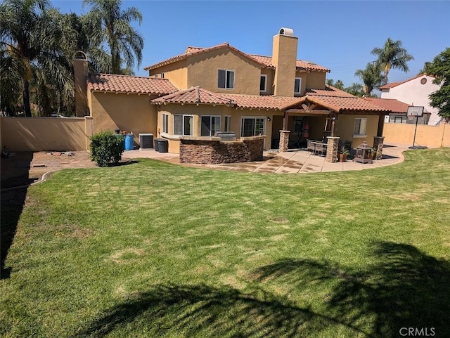 back of house featuring a lawn, central air condition unit, and a patio