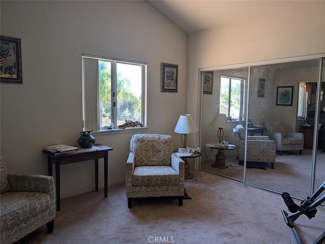 living area with a wealth of natural light, carpet, and lofted ceiling