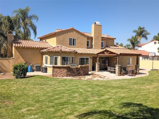 back of house featuring a lawn, a patio area, and central AC