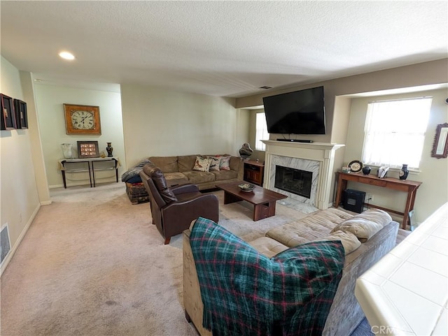 living room featuring a textured ceiling, light colored carpet, and a fireplace