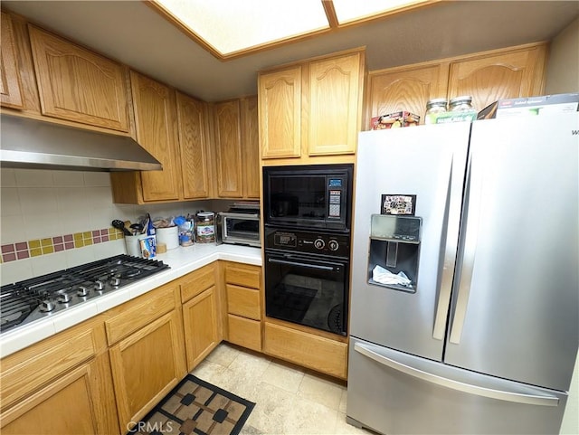 kitchen with backsplash, tile countertops, and black appliances