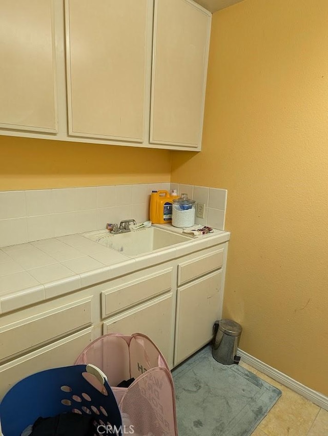 laundry room featuring light tile patterned flooring and sink