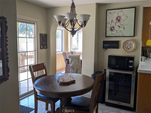 dining room featuring a notable chandelier and beverage cooler