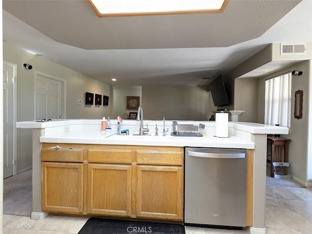 kitchen with sink, an island with sink, stainless steel dishwasher, and a textured ceiling