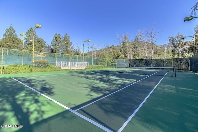 view of tennis court with a mountain view