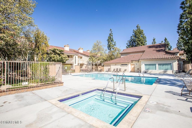 view of swimming pool featuring a community hot tub and a patio area