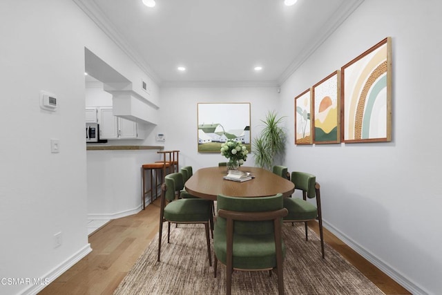 dining area featuring hardwood / wood-style flooring and ornamental molding