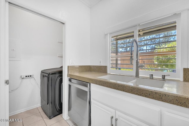 clothes washing area with light tile patterned flooring, washer / dryer, and sink