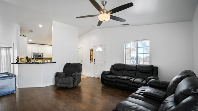 living room featuring dark hardwood / wood-style floors, ceiling fan, and vaulted ceiling