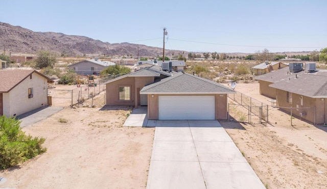 view of front facade featuring central AC, a mountain view, and a garage